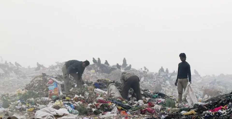 Workers on top of the Ghazipur landfill in Delhi