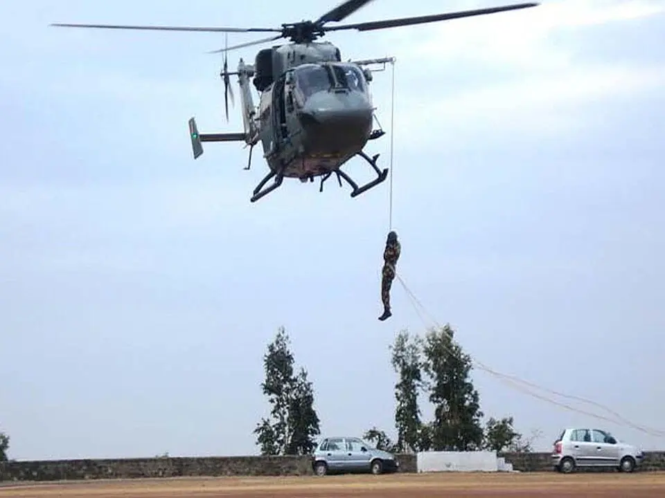NDRF personnel practising helislithering from a helicopter