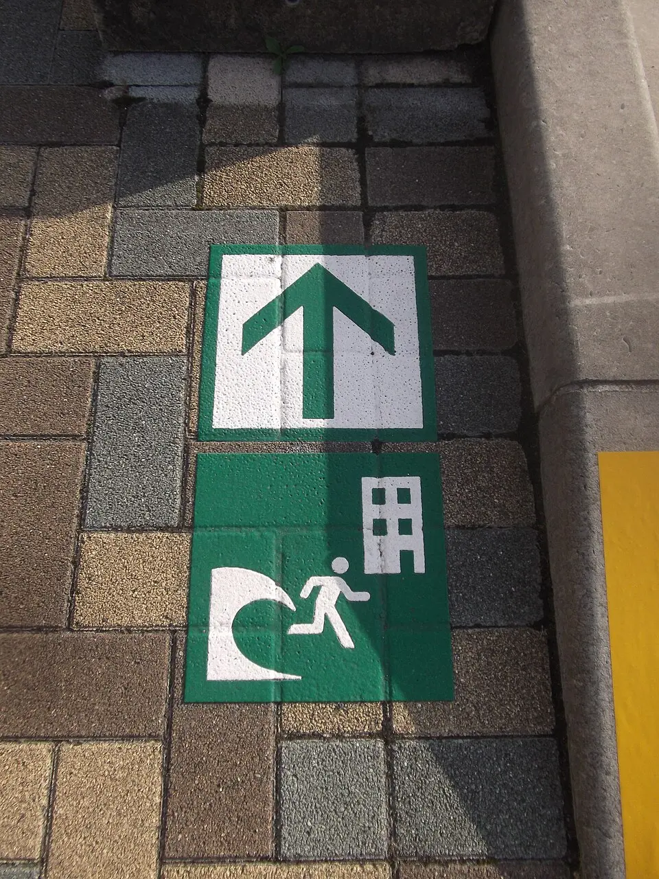 Street sign in Japan showing the route to a tsunami evacuation building
