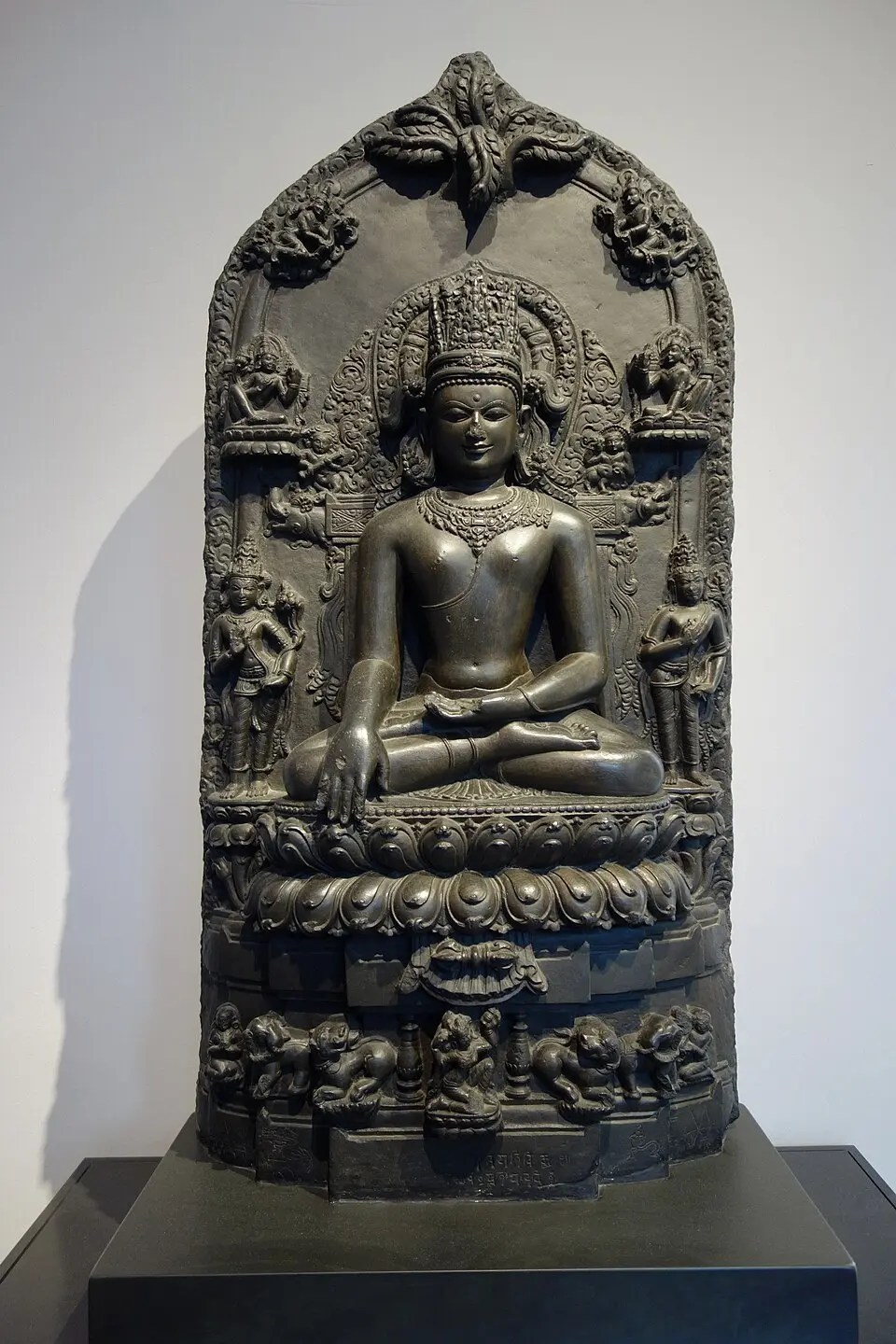 A crowned Buddha of the Pala period: The Pala school worked in black basalt, with elongated graceful forms and elaborate crowns and halos.